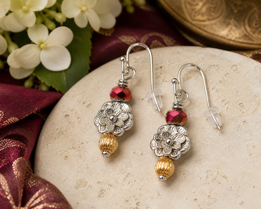 Floral silver and gold earrings with red bead styled on elegant neutral background feminine jewelry