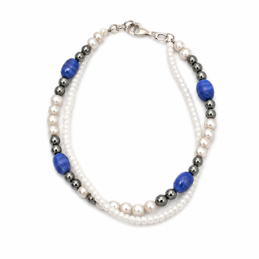 Main - Handmade dual strand bracelet with white seed beads, metallic hematite beads, pearl accents, and royal blue accent beads on a clean white background.