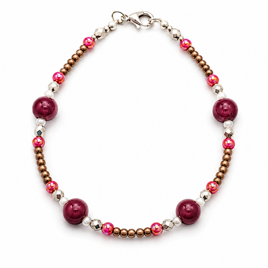 Handmade burgundy beaded bracelet with bronze seed beads, pink shimmer accents, silver faceted spacers, and pearl details on white background