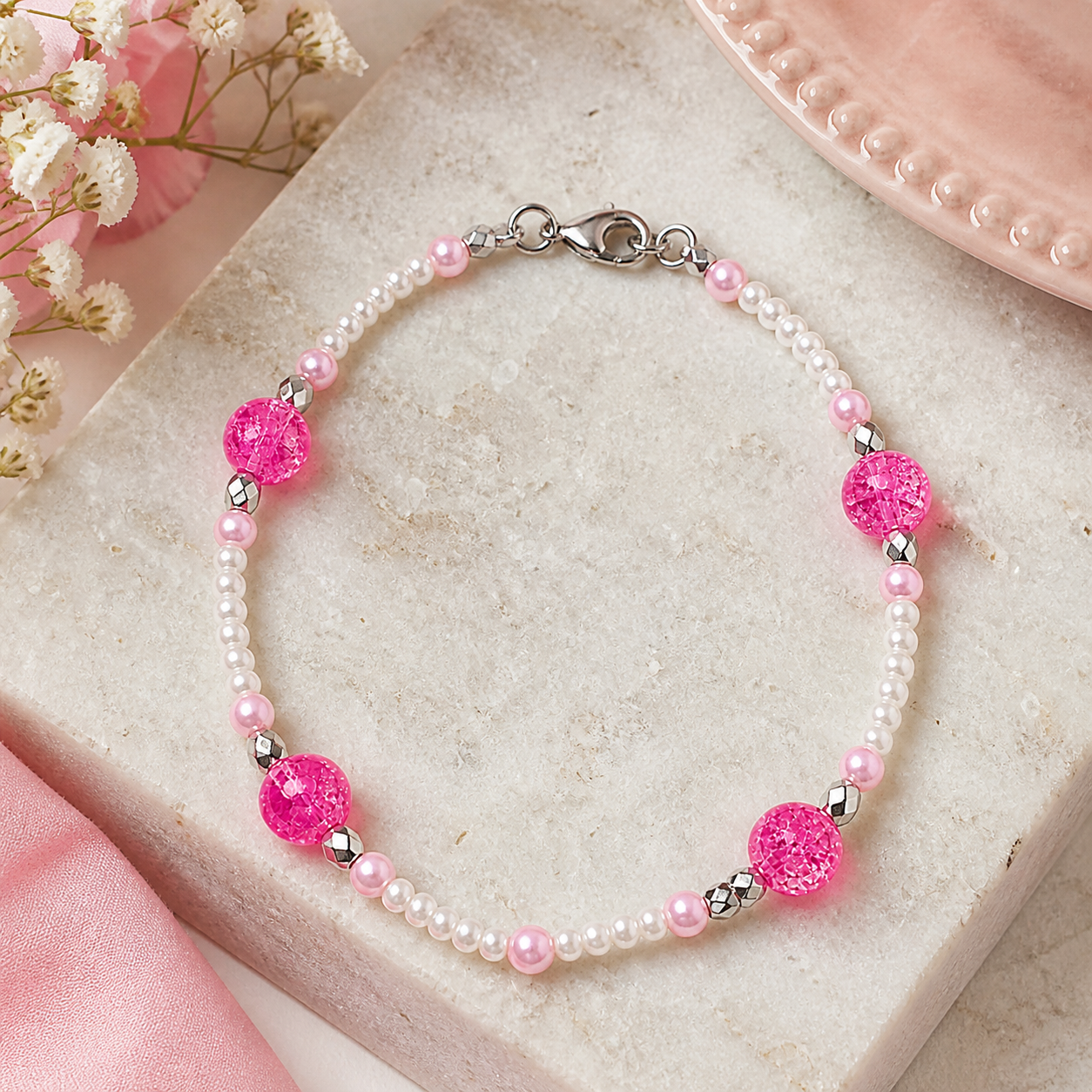 Pink and pearl beaded bracelet styled on neutral marble background feminine handmade jewelry