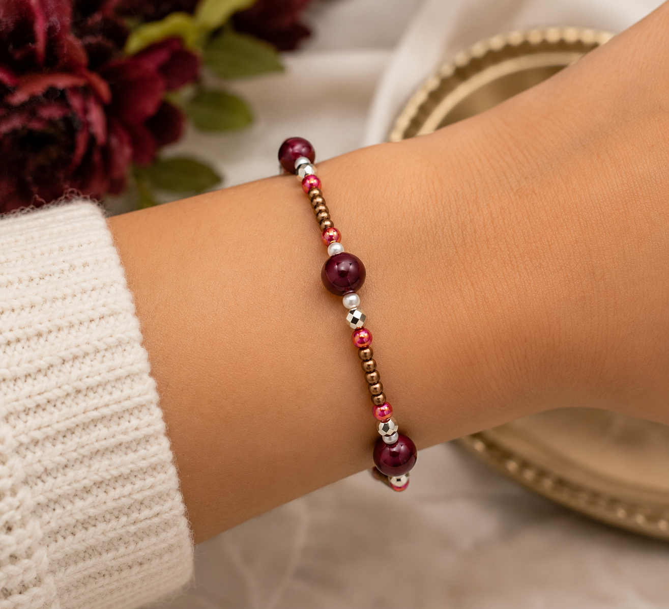Woman wearing lightweight burgundy bracelet with bronze beads, silver accents, and deep red focal beads in elegant lifestyle jewelry photo