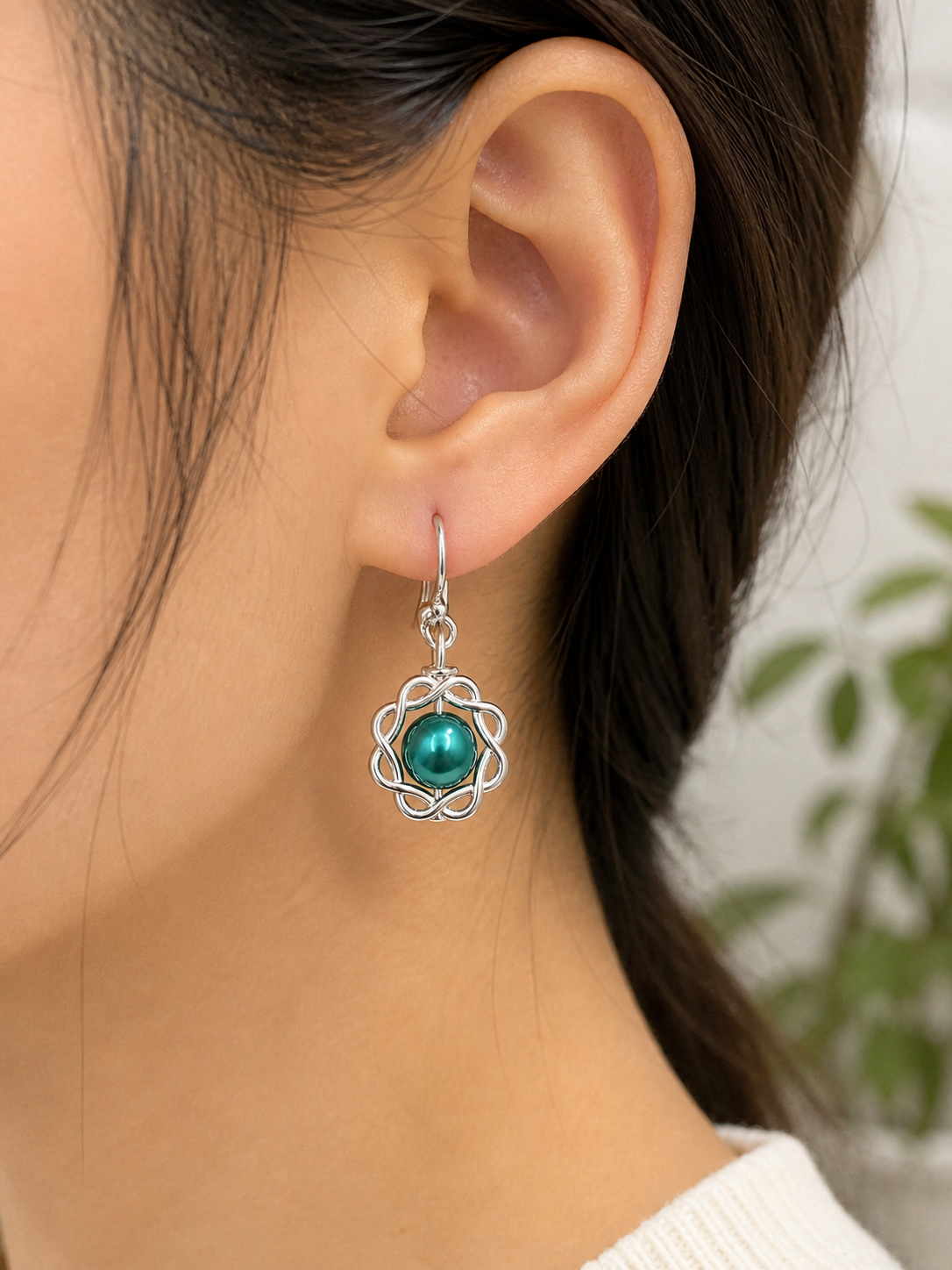 Woman wearing green pearl swirl drop earrings close up elegant lightweight jewelry