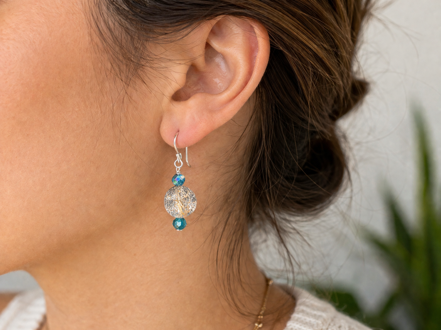 Woman wearing clear crackle glass drop earrings with teal beads close up lightweight handmade jewelry