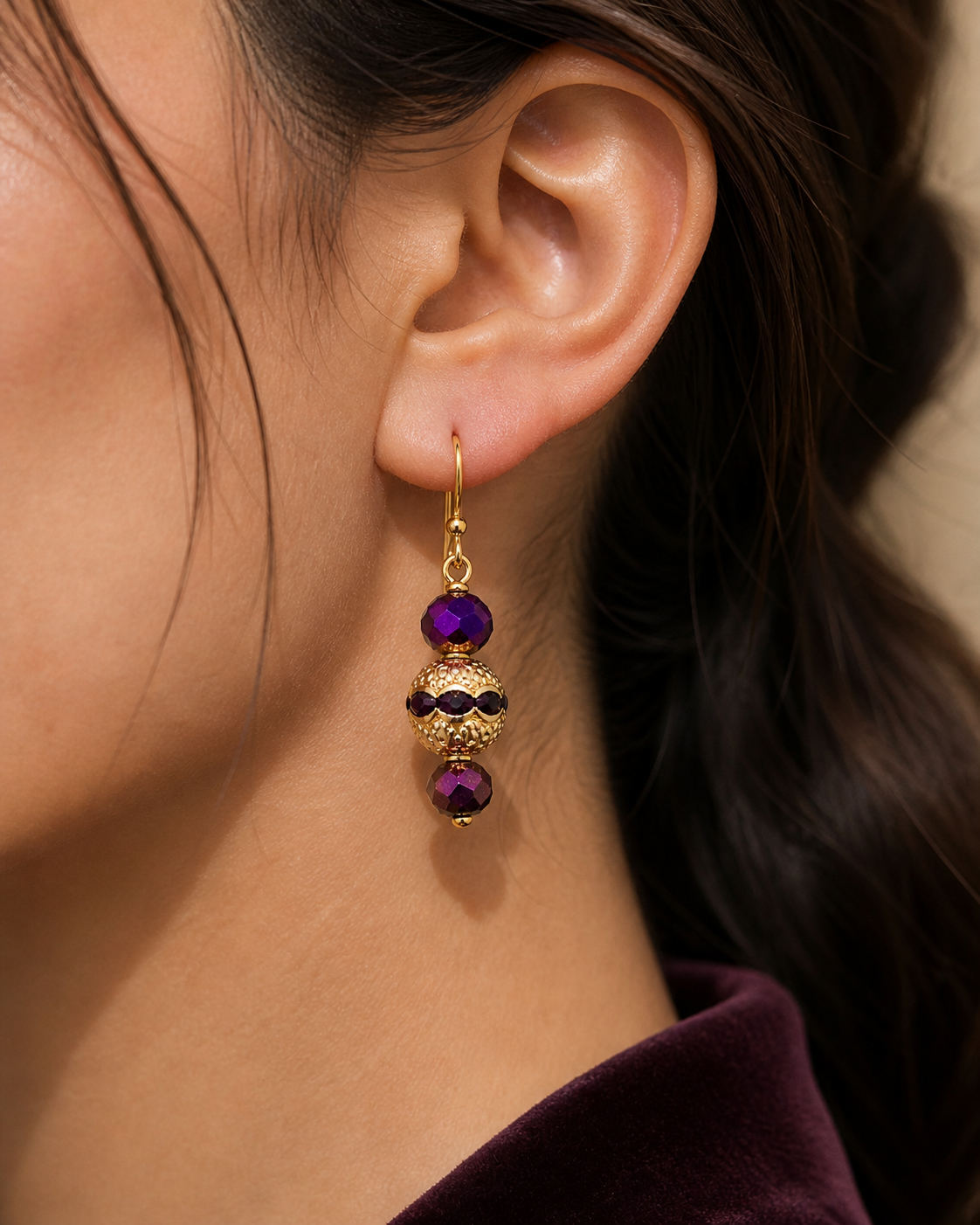 Woman wearing purple and gold drop earrings close up elegant lightweight jewelry