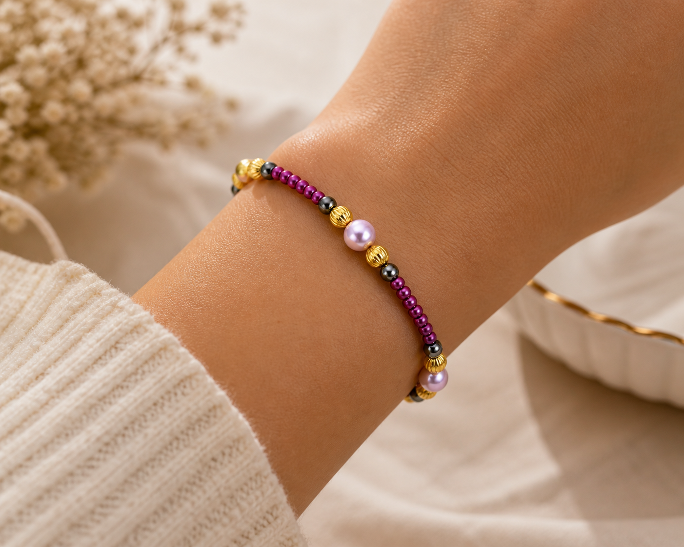 Woman wearing purple beaded bracelet with pearls and gold accents close up lightweight jewelry