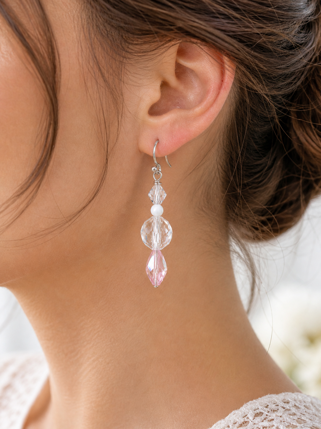 Woman wearing blush crystal drop earrings with soft pink bead close up lightweight elegant jewelry