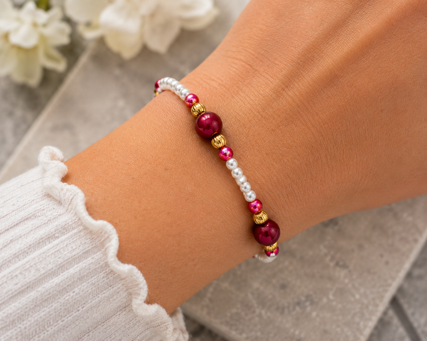 Worn - Handmade pearl and berry beaded bracelet worn on wrist featuring white pearls, gold spacers, and rich magenta beads.