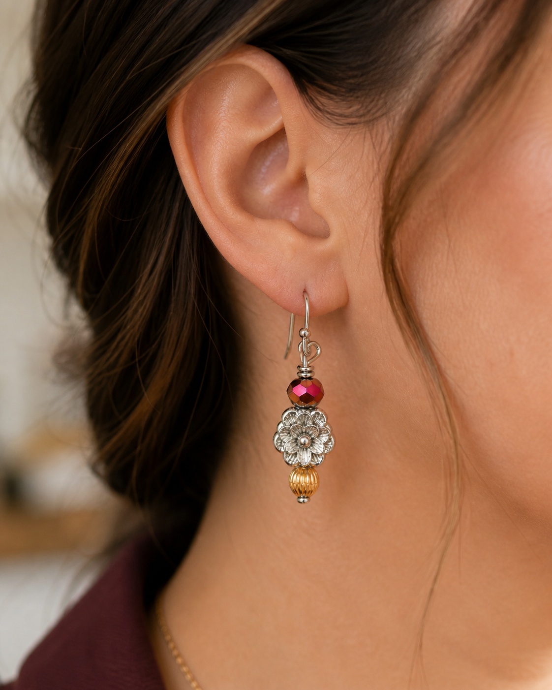 Woman wearing silver flower drop earrings with red bead close up feminine lightweight jewelry