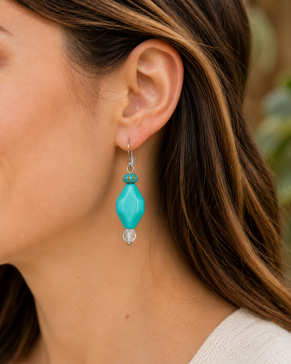 Woman wearing turquoise drop earrings with crystal bead close up lightweight boho jewelry