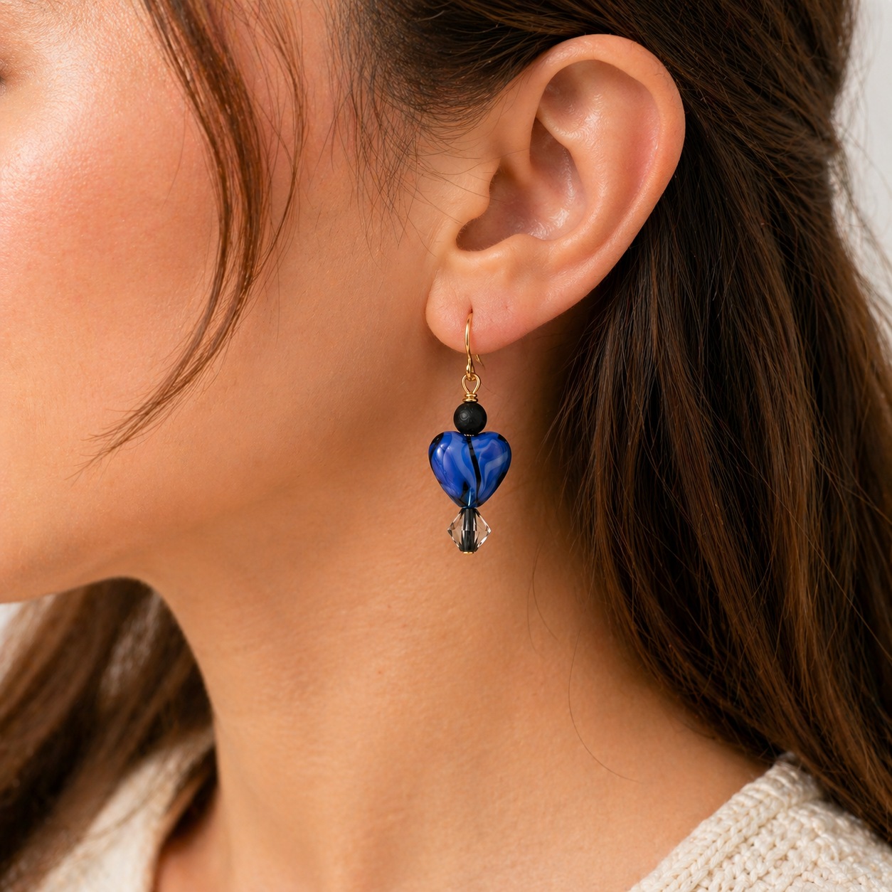 Woman wearing blue heart dangle earrings close up lightweight jewelry